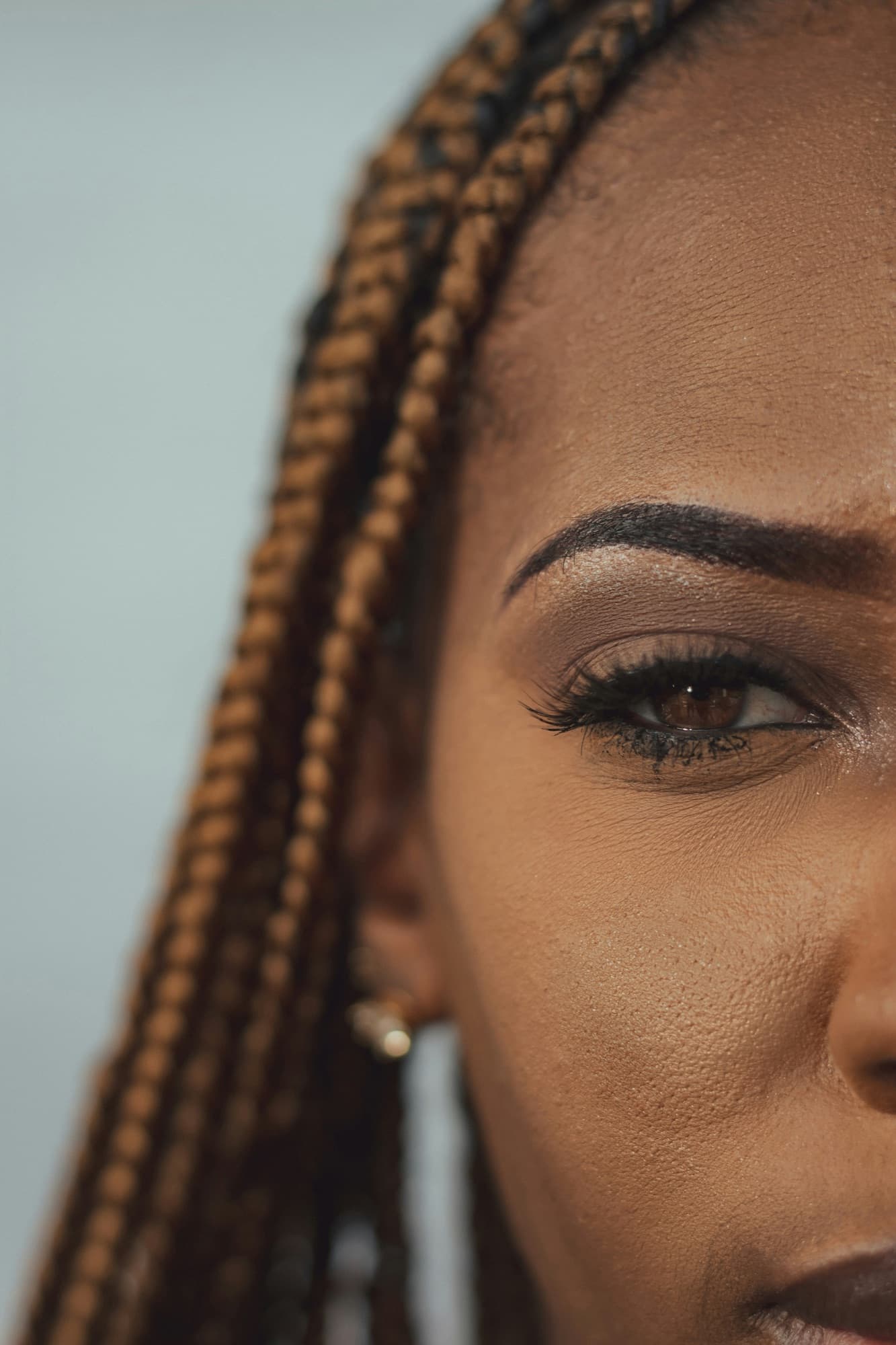 Close-up of a made-up eye, lashes and braids