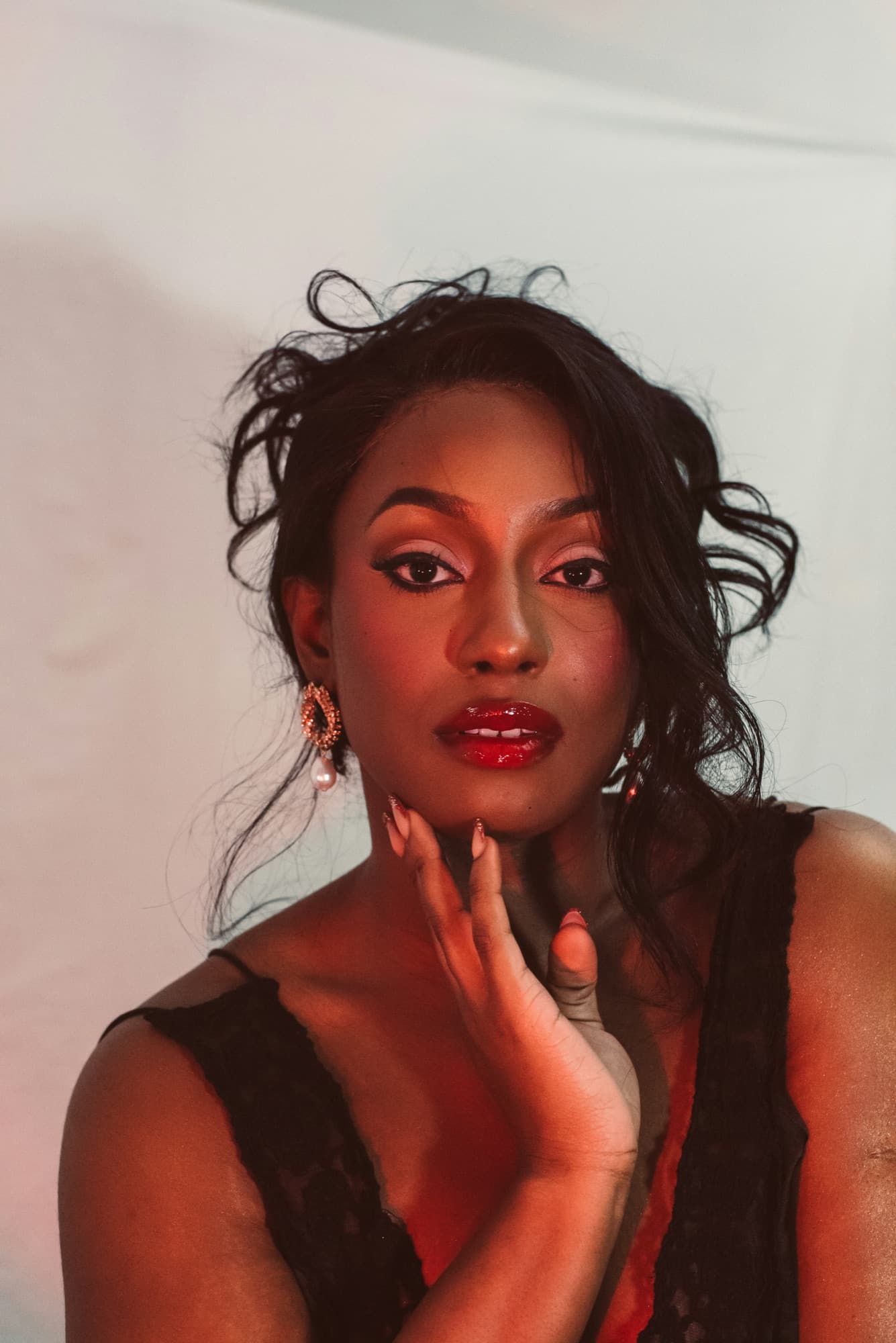 Woman with manicured nails, her hand resting against her face